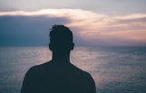silhouette photography of man standing near sea
