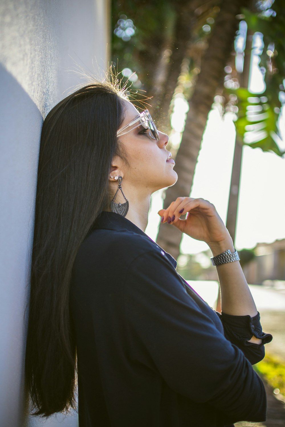 woman in black long-sleeved shirt standing against wall