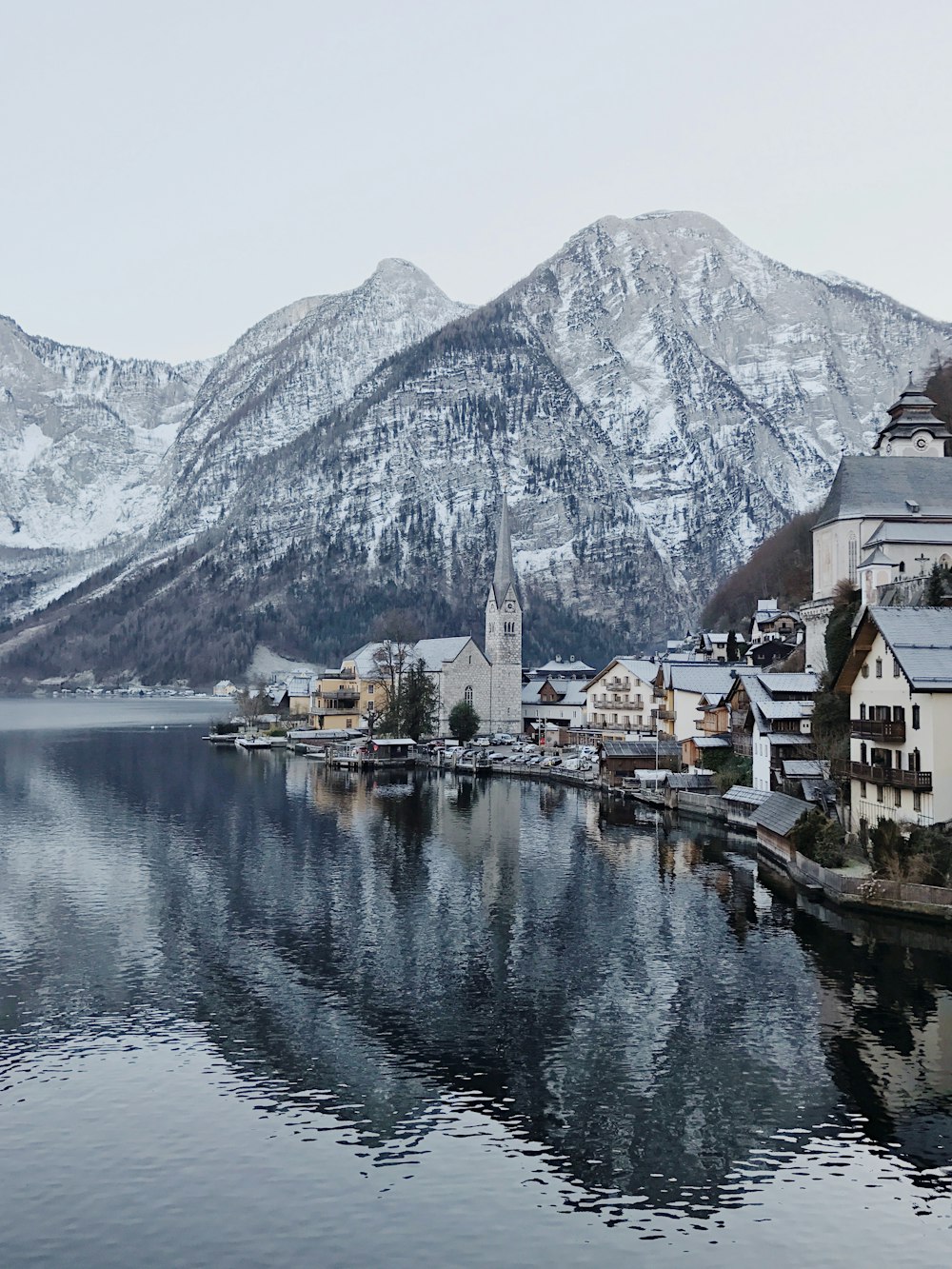 village near body of water and mountains