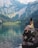 woman sitting on rock near lake