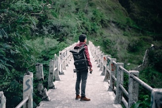 man standing on gray concrete bridge taken at daytime