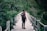 man standing on gray concrete bridge taken at daytime