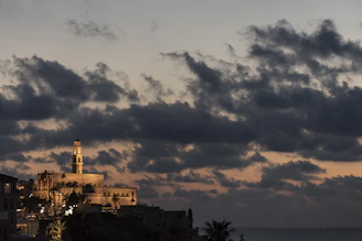 Historic mission bell tower silhouetted against a vibrant sunset sky.