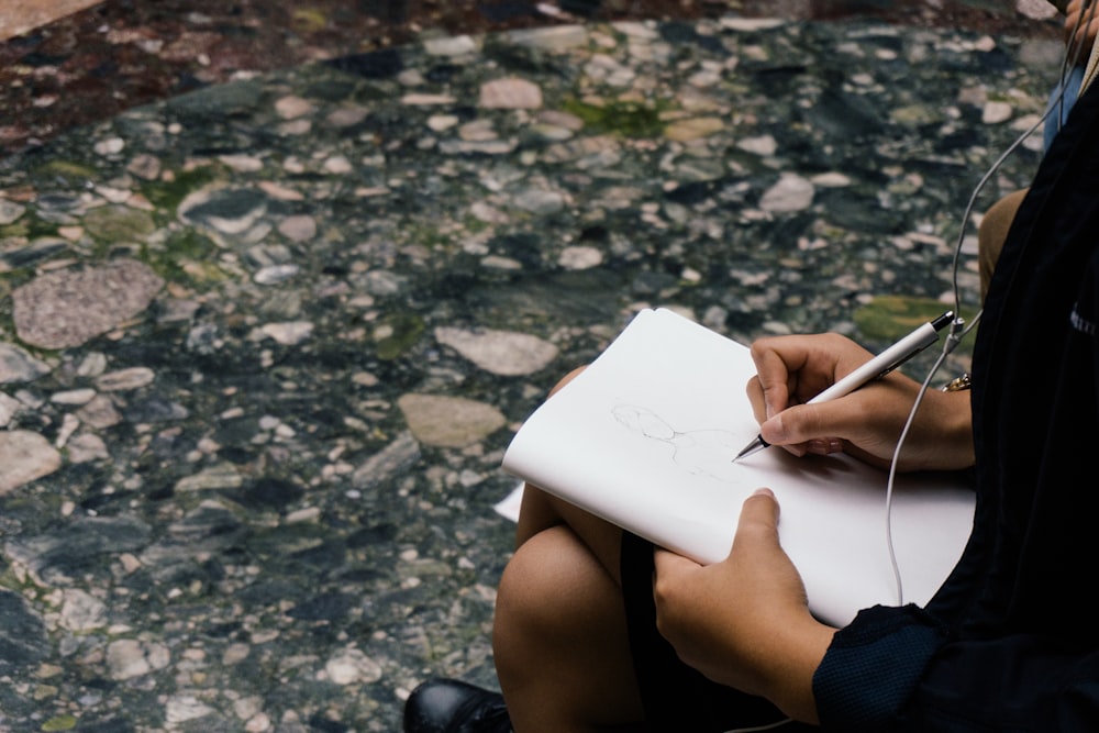 person sitting while writing