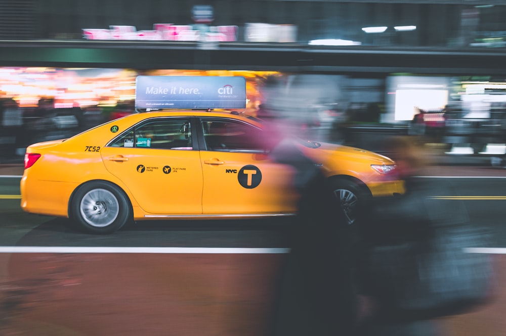 yellow sedan on gray road