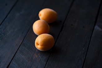 three fruits on wooden surface