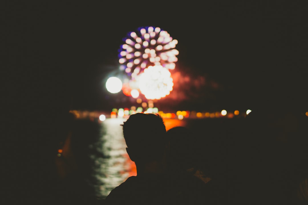 silhouette of person in front of fireworks