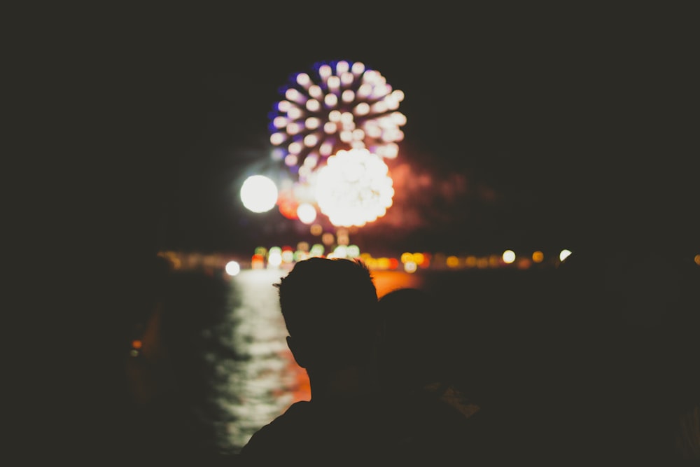 silhouette of person in front of fireworks