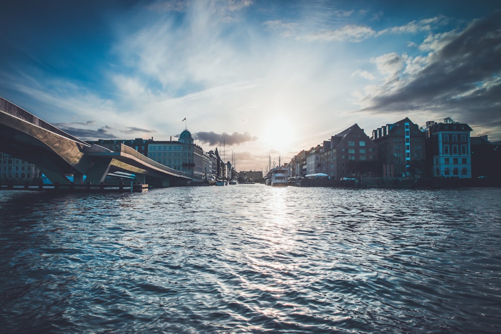 concrete bridge leading to city surrounded by water