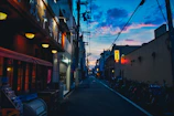 A quiet urban street scene at twilight with glowing street lamps.