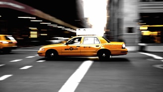 panning photography of yellow taxi on road