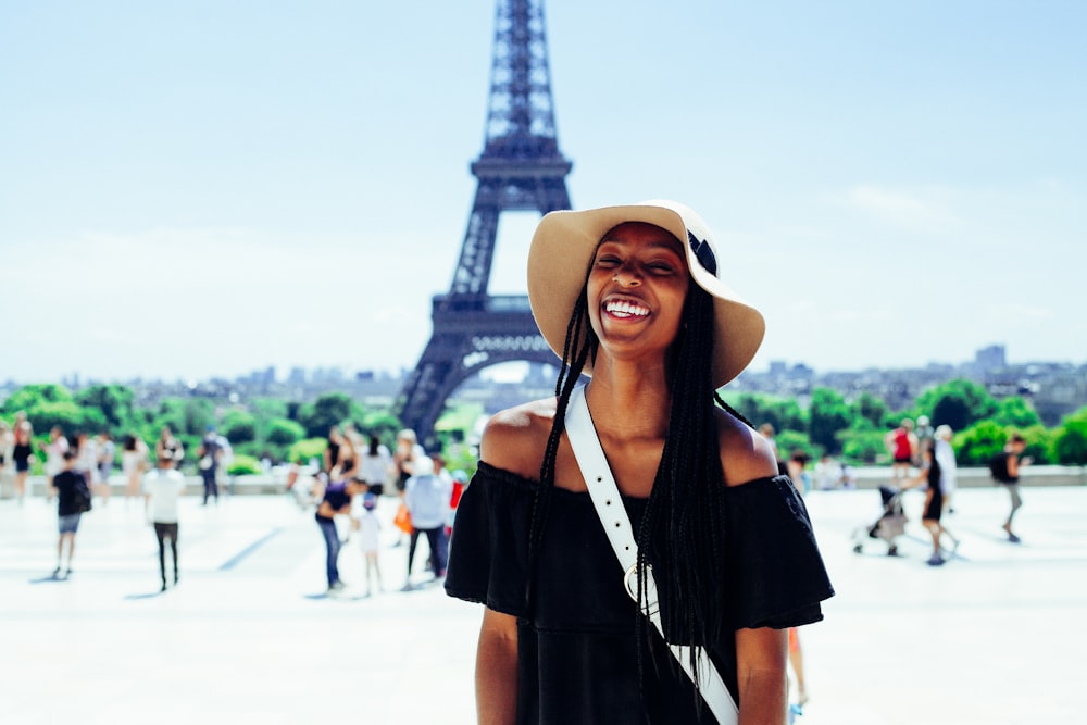 mujer de pie detrás de la Torre Eiffel durante el día