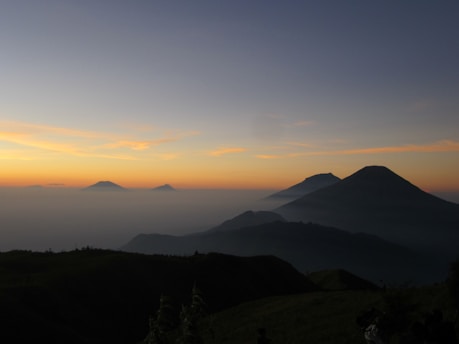 A serene mountain landscape at dawn with soft pastel colors and gentle mist rolling over Appalachian peaks.