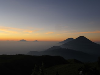 A serene landscape photo of the Andes mountains at sunrise with mist rolling over the peaks.