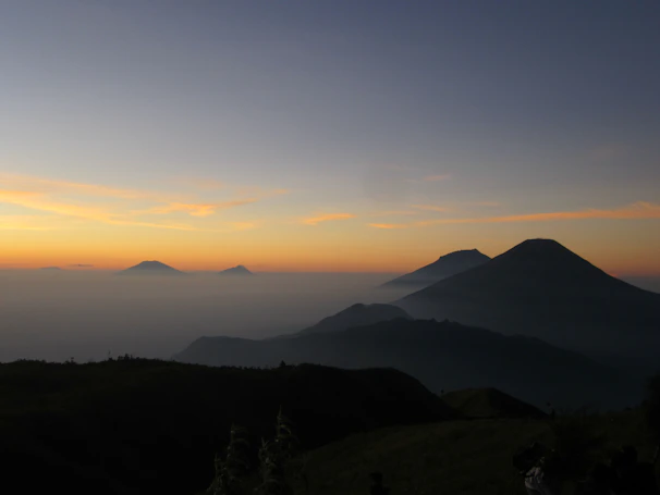 A serene sunrise over a misty mountain ridge in a national park.