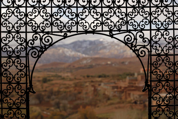 Ornate wrought iron balcony overlooking the rolling hills of the Tuscan countryside.
