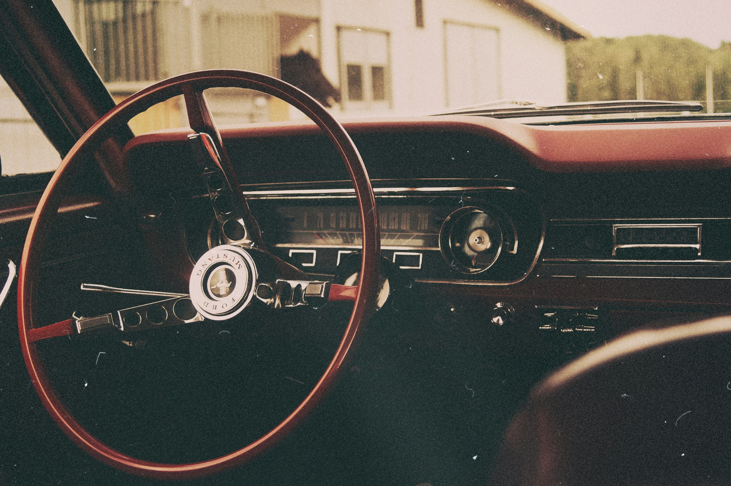 selective focus photo of red and gray car steering wheel