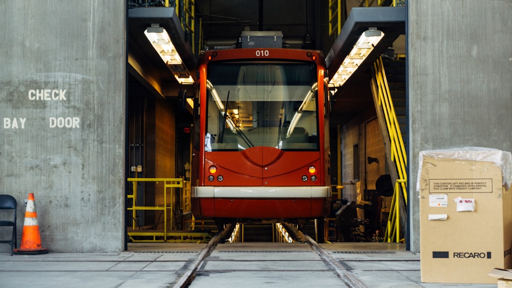 灰色のコンクリートの壁の間に赤い列車