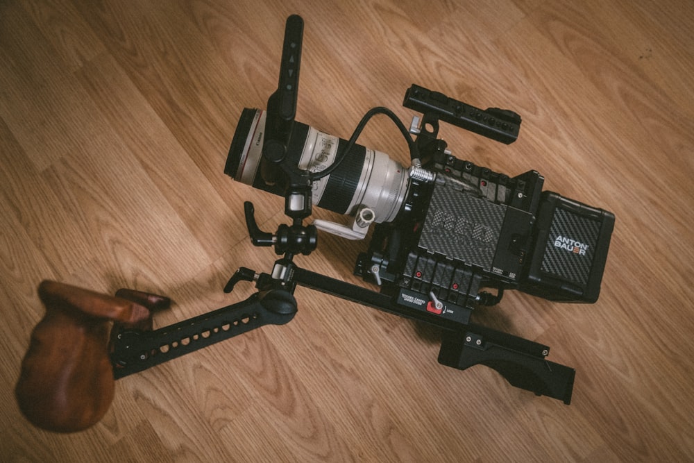 black and gray professional camera on brown wood parquet floor