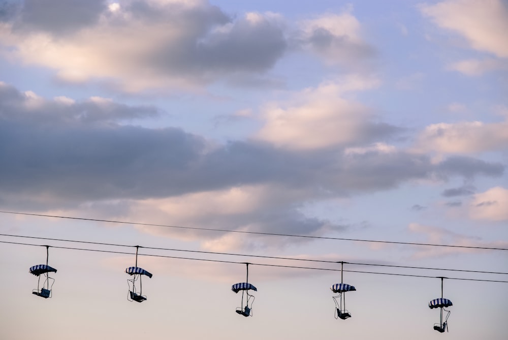 five black cable cars under white cloudy sky