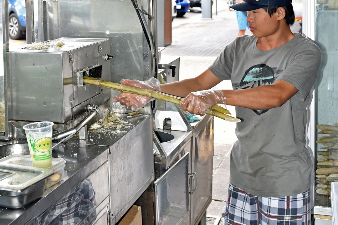 This young man is making sugar cane juice at Rusty’s markets in Cairns Australia. The juice is often mixed with limes and crushed ice to make a delightfully refreshing drink.