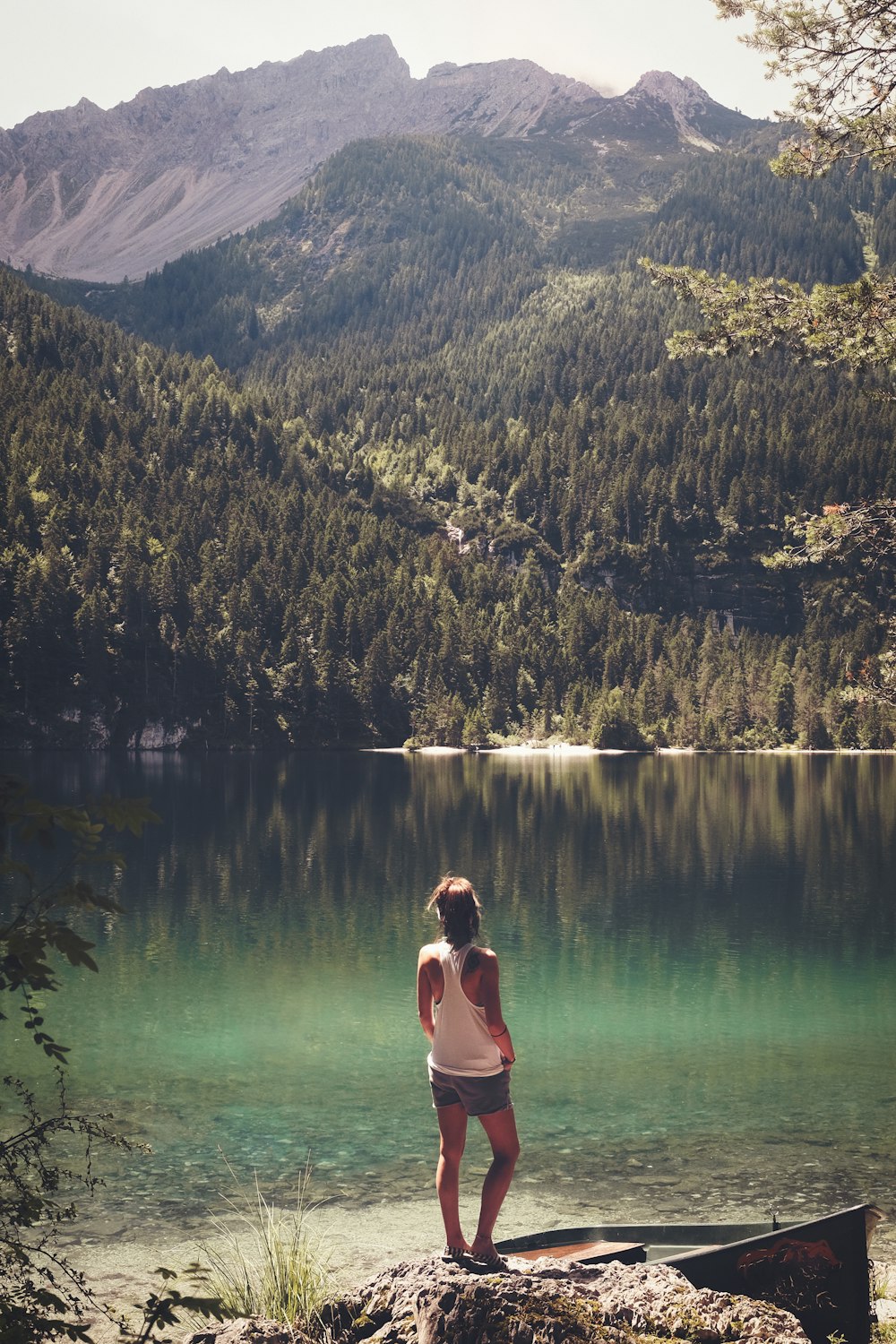 donna che si leva in piedi davanti allo specchio d'acqua