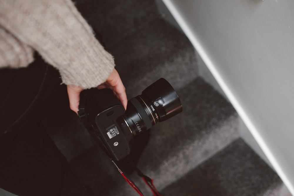 person holding black DSLR camera close-up photo