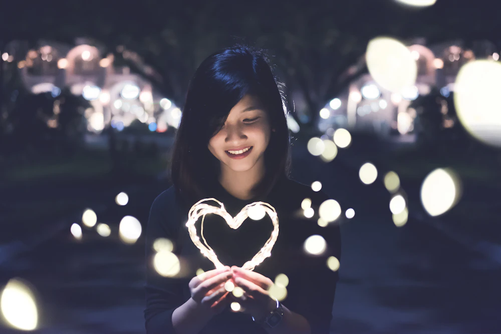 woman holding lit heart
