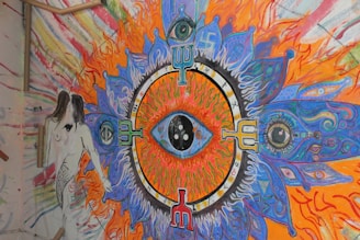 A colorful canvas with chaotic, playful patterns and a central eye motif glowing in neon hues.