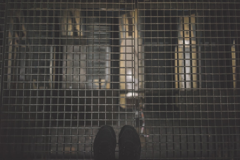 person standing on gray mesh surface