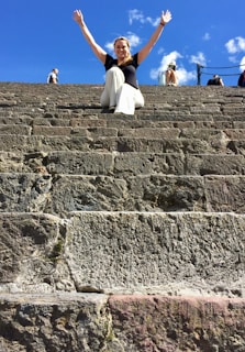 A joyful traveler standing atop Petra’s ancient stone steps at sunset, soaking in the golden hues.