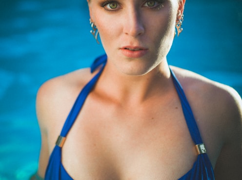 woman in blue string bikini top in pool looking straight onlyfans