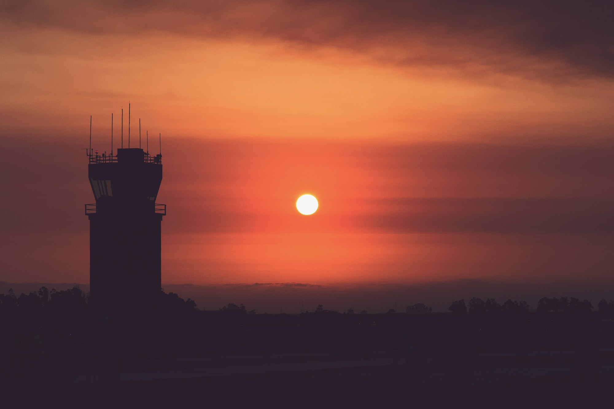 an airport control tower at sunset