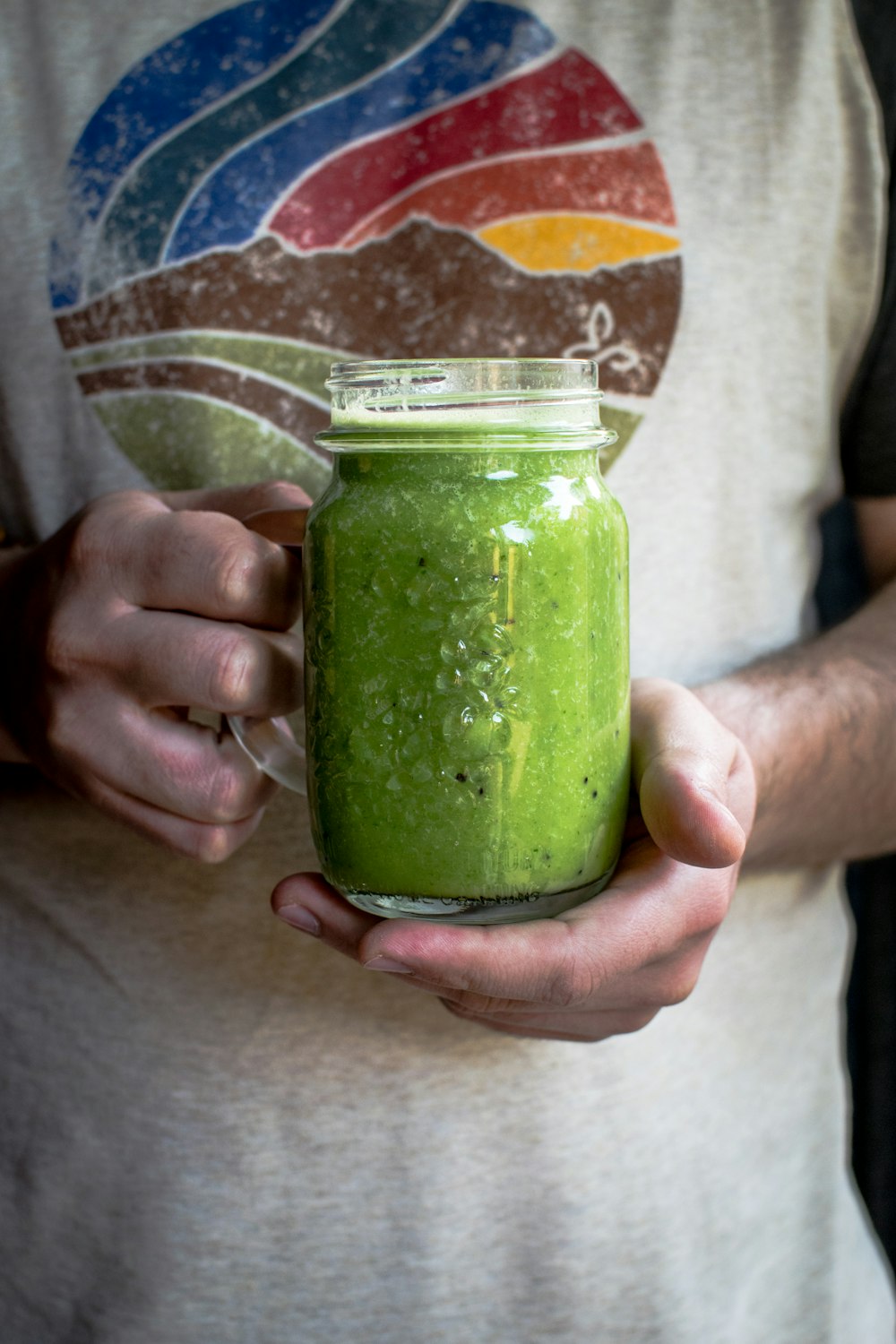 Person mit klarem Glas-Einmachbecher