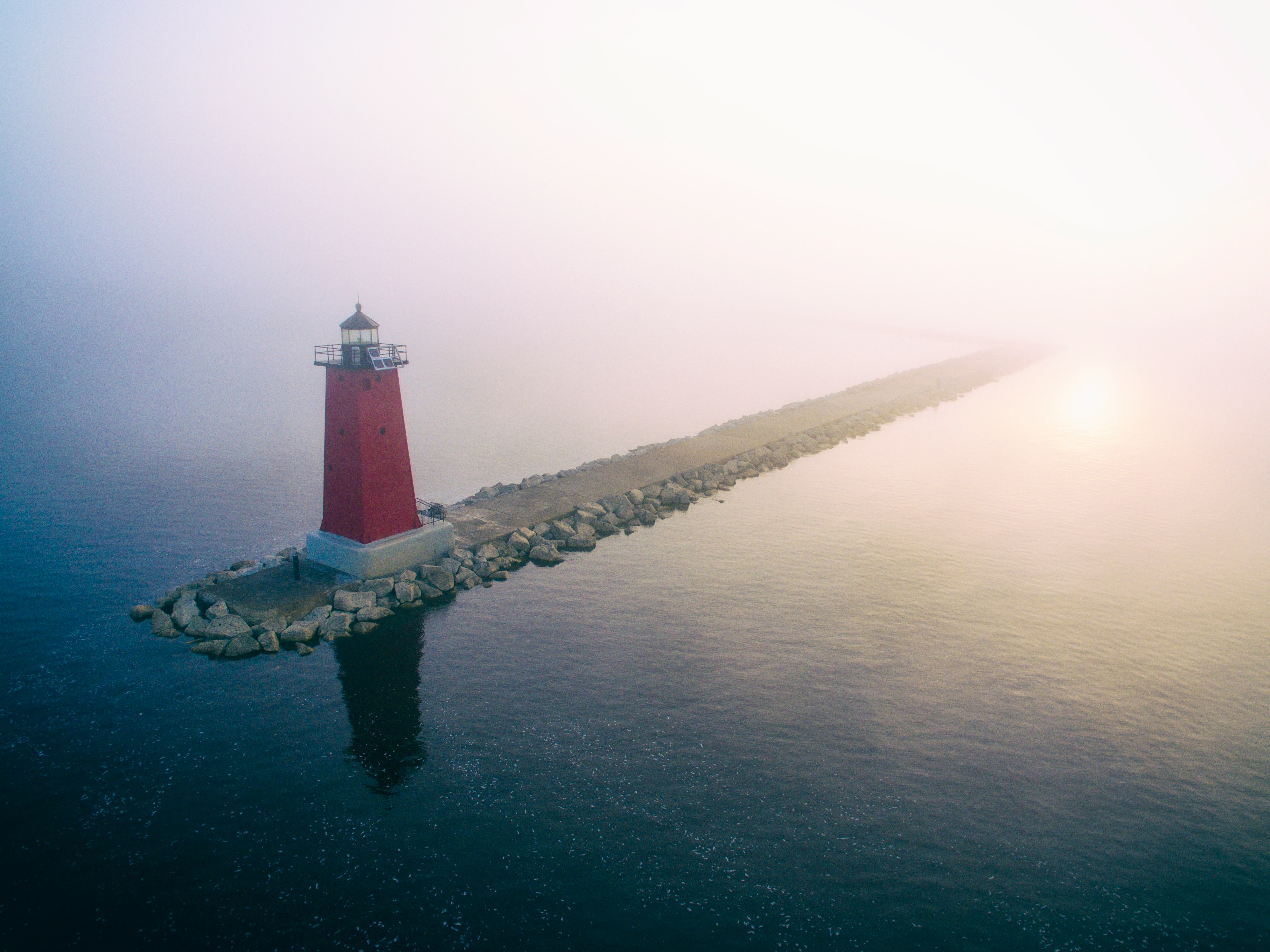 red lighthouse on gray dock at daytime