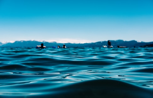 A serene landscape of the Dead Sea with people floating.