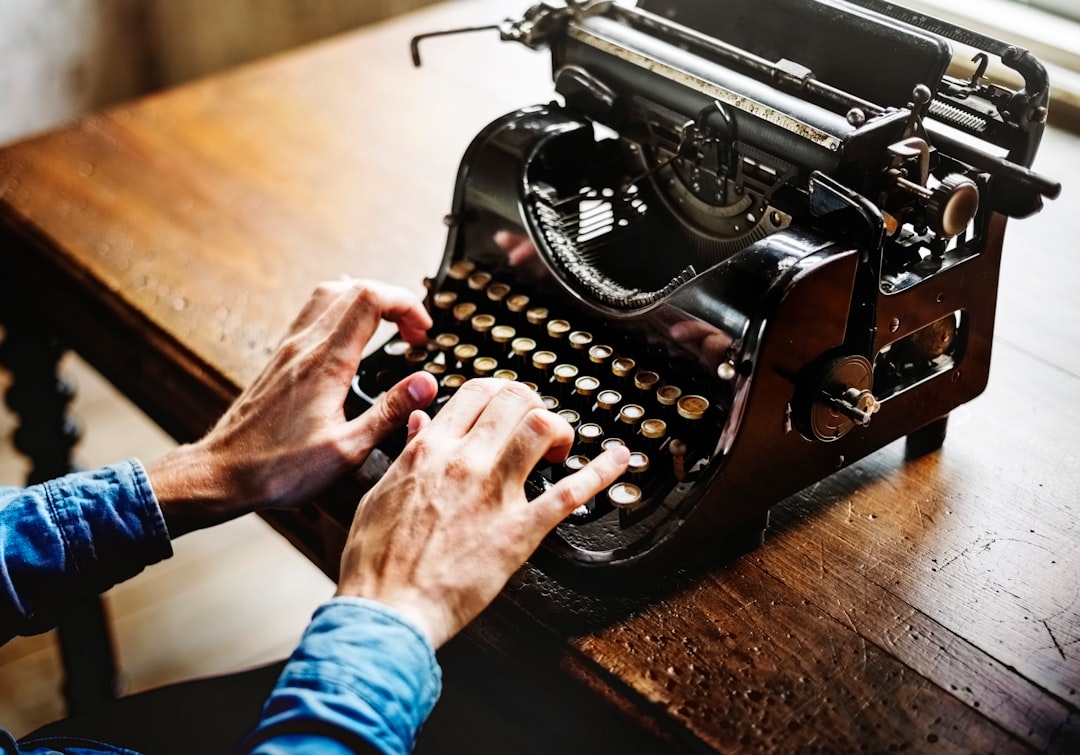 person typing on black typewriter