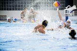 Young water polo players practicing teamwork in the pool.