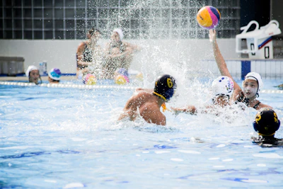 A coach guiding a group of focused water polo players during a drill.