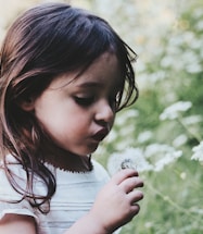 girl holding white flower during daytime