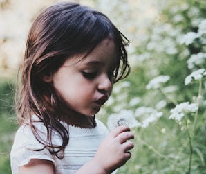 girl holding white flower during daytime