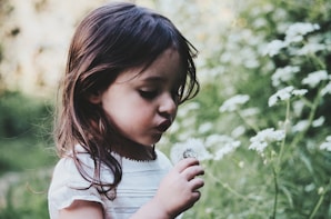 girl holding white flower during daytime