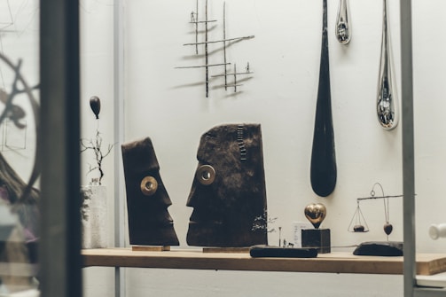 Collection of various sacred art pieces displayed on a minimalist shelf highlighting their craftsmanship.