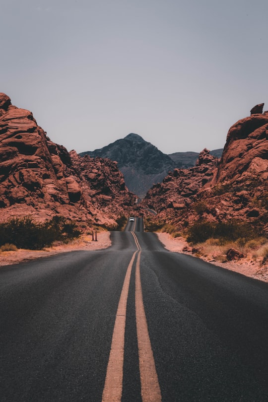 black concrete road surrounded by brown rocks in Valley of Fire State Park United States