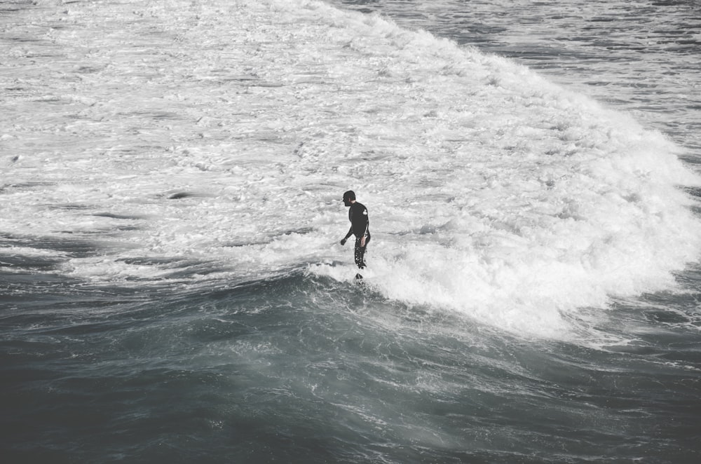 man standing on sea shore with waves