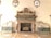 An ornate marble fireplace adorned with intricate carvings and sculptures. Flanking the fireplace are two reclining marble statues on green marble bases. Above the fireplace are three busts set within decorative niches.