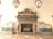 An ornate marble fireplace adorned with intricate carvings and sculptures. Flanking the fireplace are two reclining marble statues on green marble bases. Above the fireplace are three busts set within decorative niches.