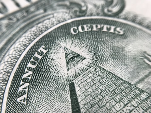 An intricate emblem of the Illuminati symbol engraved on ancient parchment.