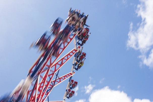 A couple enjoying a thrilling roller coaster ride at a vibrant theme park.