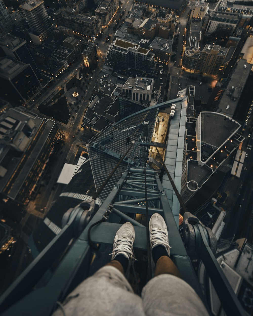 Persona in piedi sulla struttura d'acciaio grigia in cima all'edificio